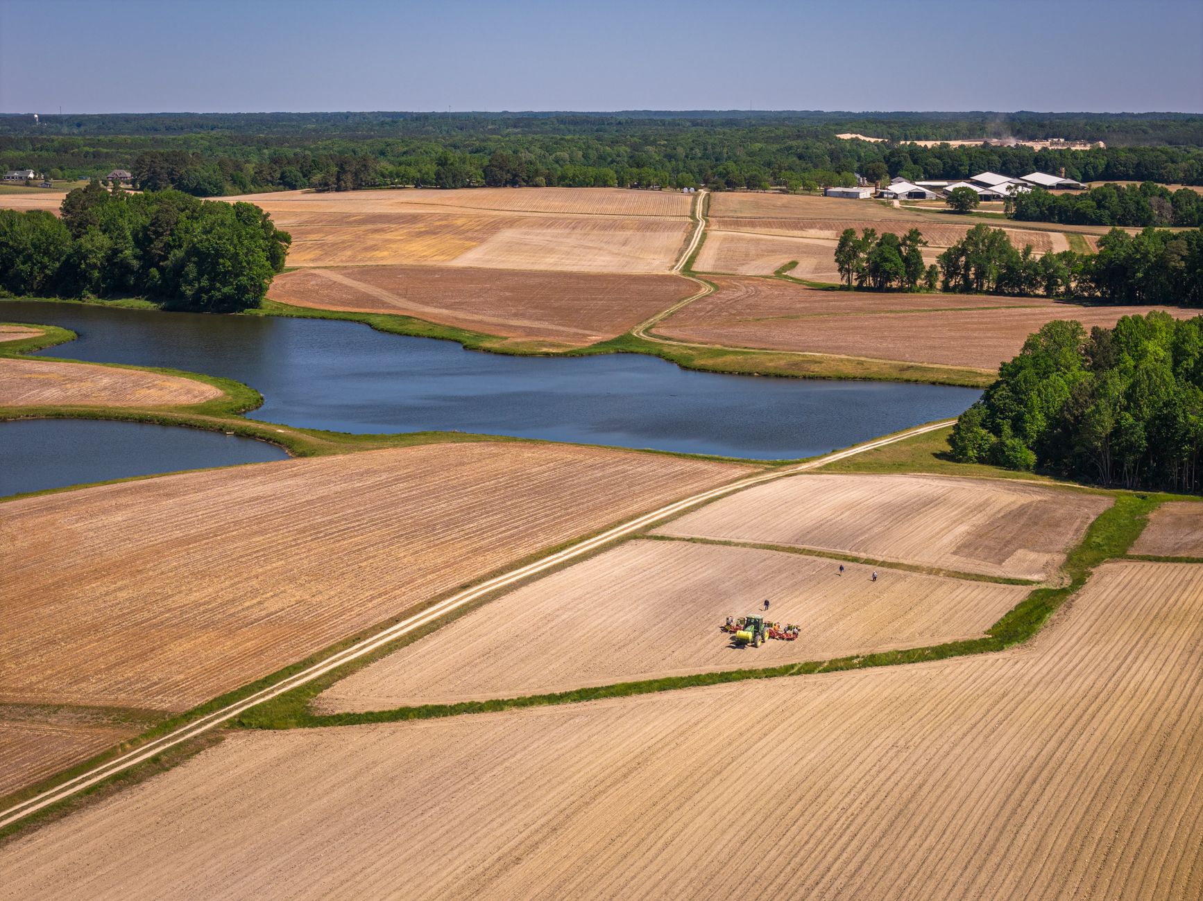 Rural Sussex County, Delaware farmland with open fields and farm buildings, golden hour.