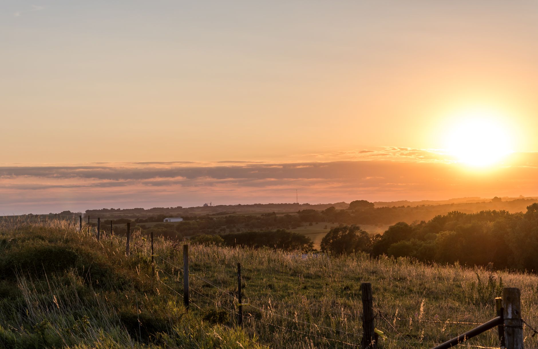 Open rural farmland and rangeland at golden hour, representing land that may pass through probate to new owners