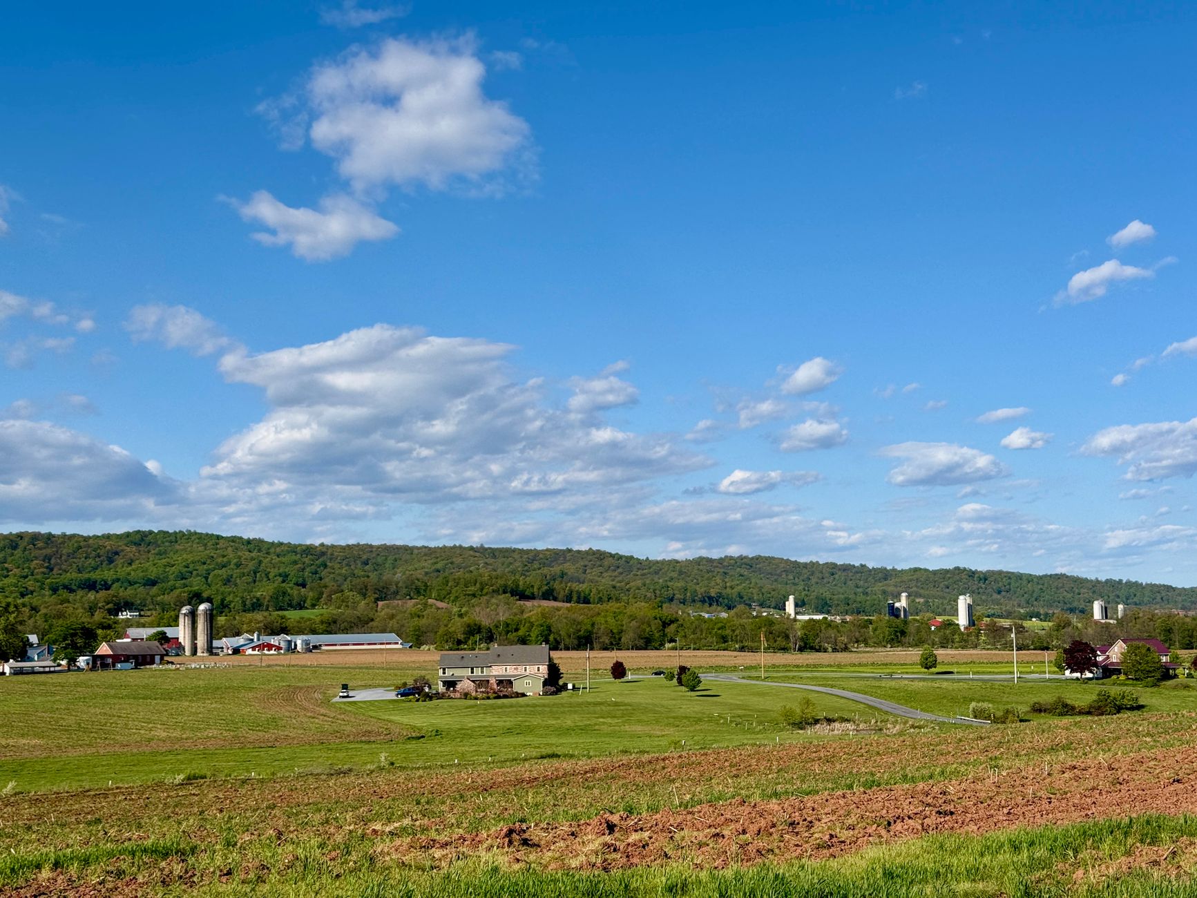 Aerial view of rural Pennsylvania farmland and rolling hills at golden hour, representative of vacant land for sale in Pennsylvania.