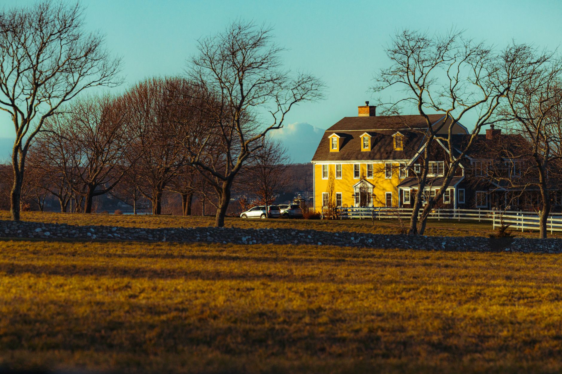 Rural Rhode Island farmland with stone walls and open fields at golden hour