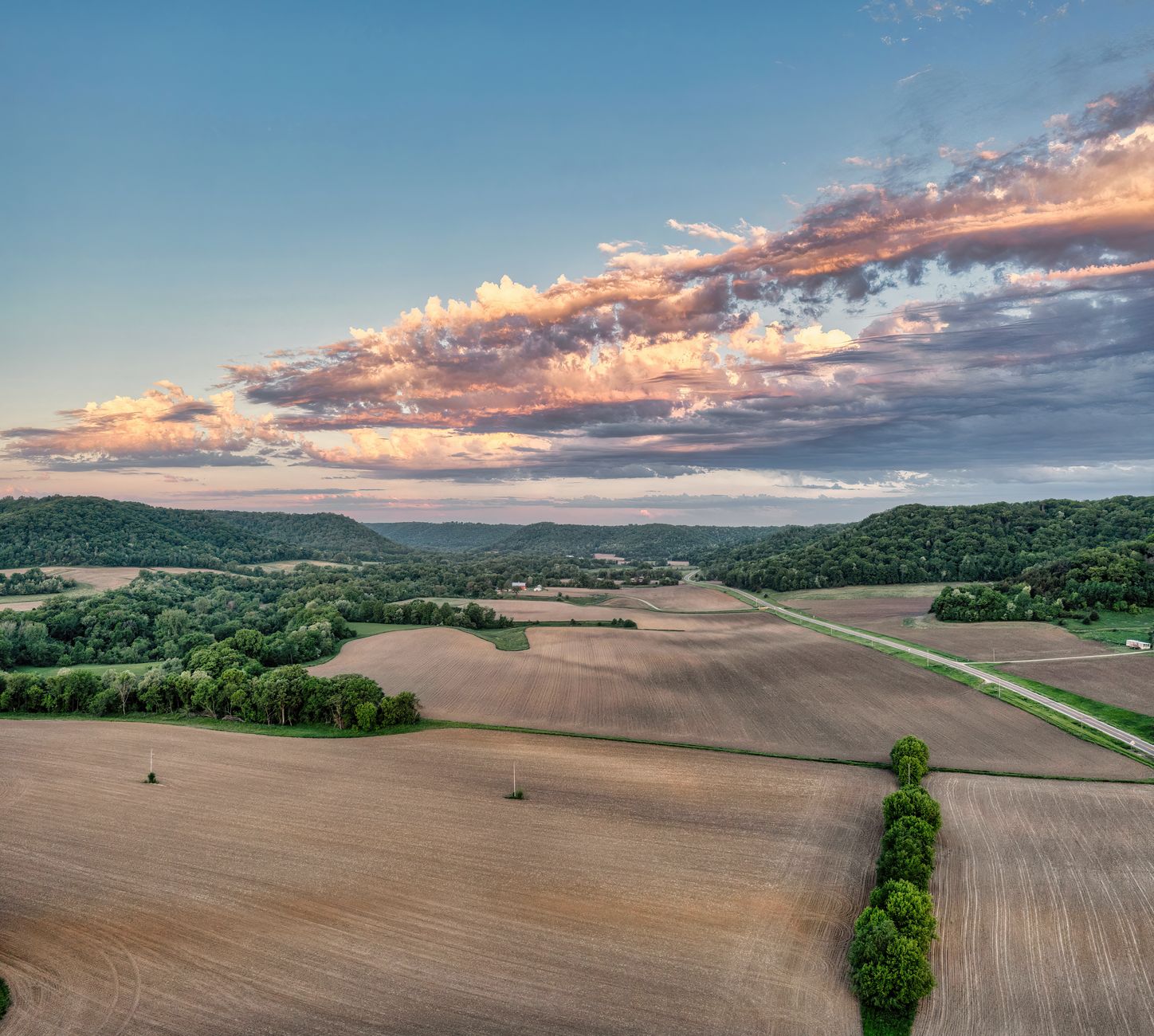 Rolling Ozark Mountain pasture and forested ridgeline representative of Carroll County, Arkansas land.