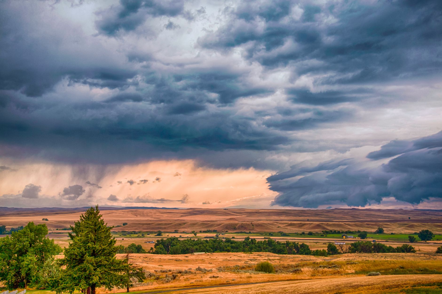 Wide-open rural farmland and rangeland at golden hour, representing land that may carry significant capital gains exposure for a long-time owner.